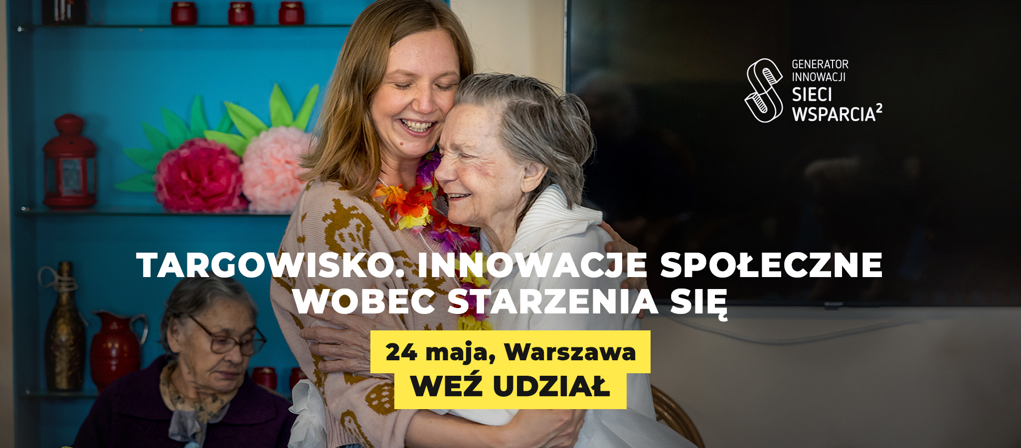 Nazwa wydarzenia "Targowisko. Innowacje społeczne wobec starzenia się.", 24 maja Warszawa. Weź udział! W tle zdjęcie starszej i młodszej kobiety przytulających się i uśmiechających.