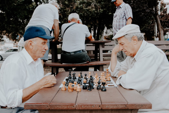 Zdjęcie przedstawia dwóch seniorów grających w szachy
