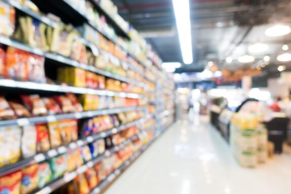 rozmazany obraz przedstawiający półki sklepowe w supermarkecie