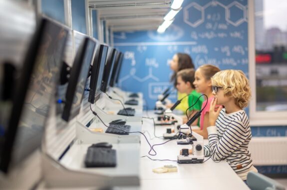Uczniowie w klasie podczas lekcji korzystają z technologicznych rozwiązań