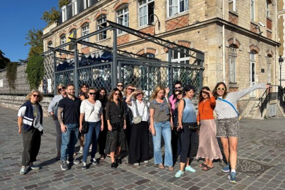 grupa ludzi na tle budynku w słoneczny dzień