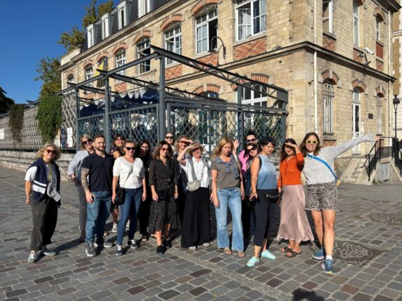 grupa ludzi na tle budynku w słoneczny dzień