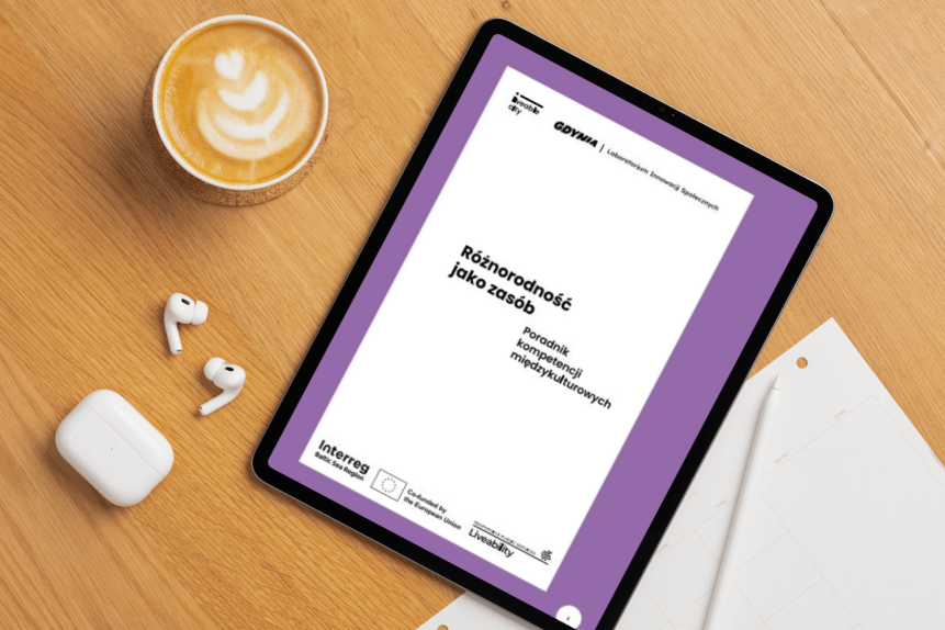 Na stole leży ipad, na ekranie którego wyświetlona jest strona tytułowa poradnika "Różnorodność jako zasób"