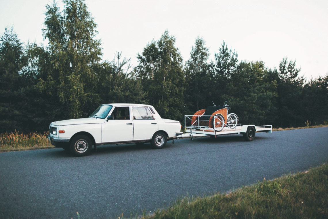 Na zdjęciu znajduje się riksza przewożona na przyczepce