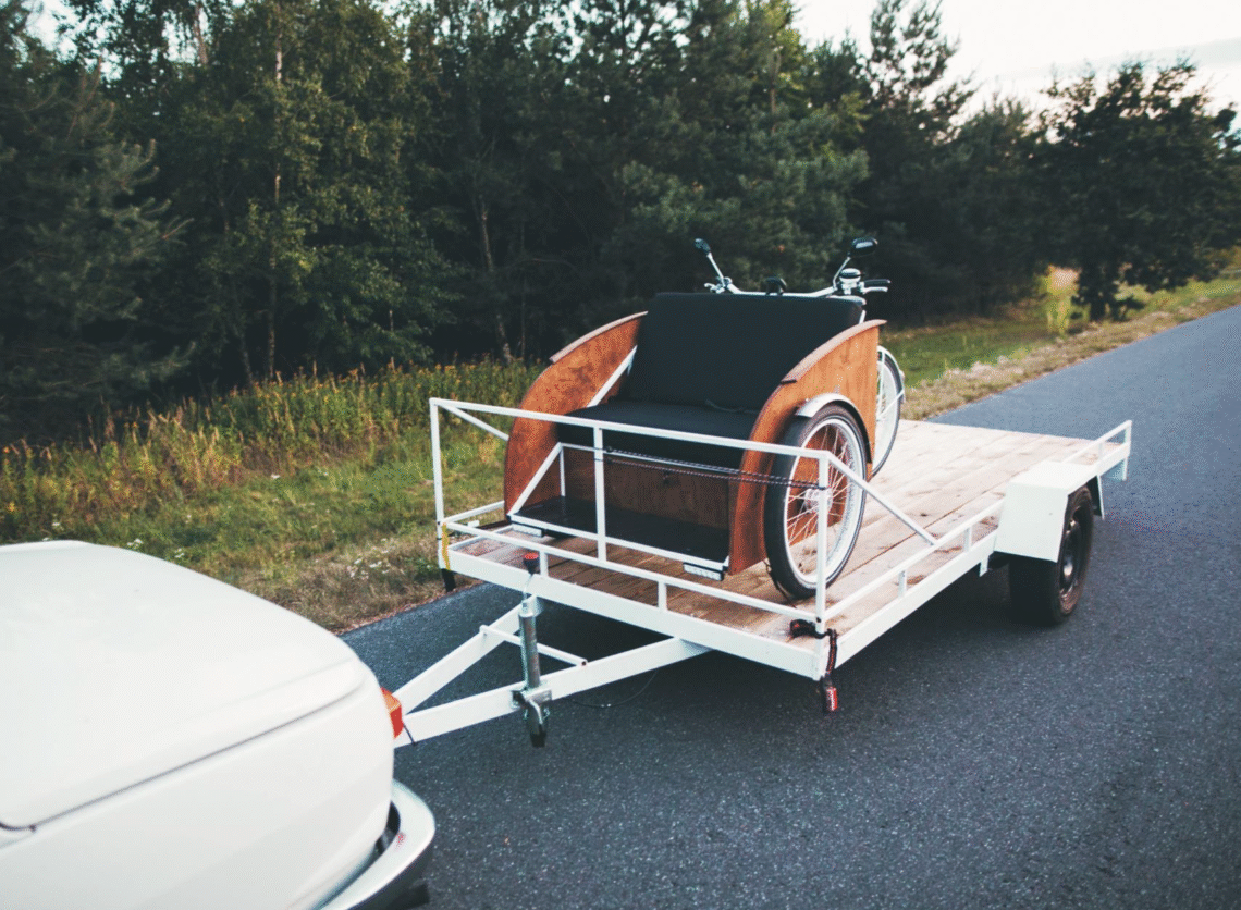 Na zdjęciu znajduje się riksza przewożona na przyczepce
