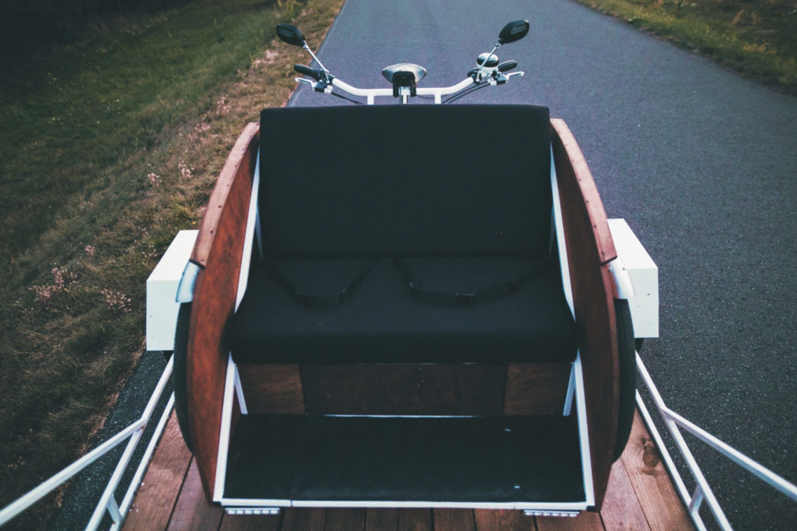 Na zdjęciu znajduje się riksza przewożona na przyczepce