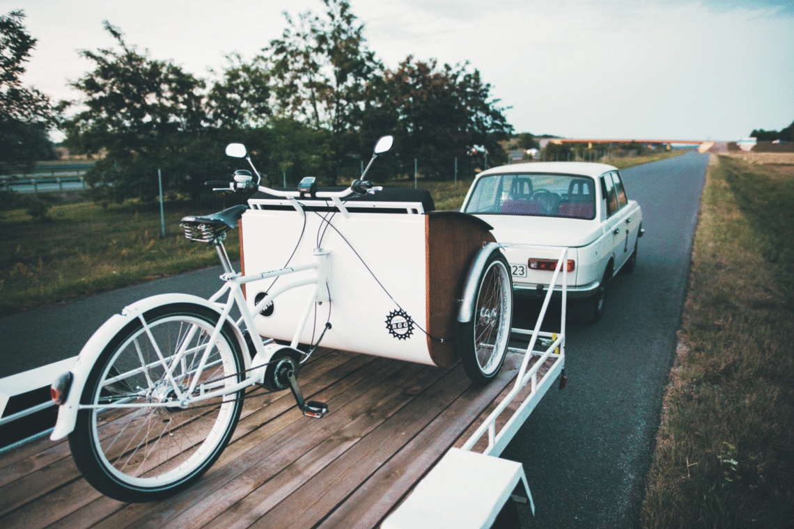 Na zdjęciu znajduje się riksza przewożona na przyczepce