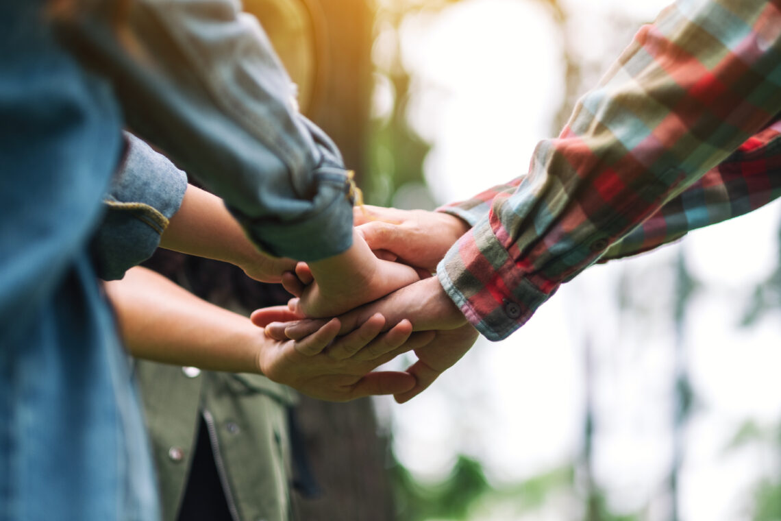 Ręce położone jedna na drugiej w geście solidarności, współpracy