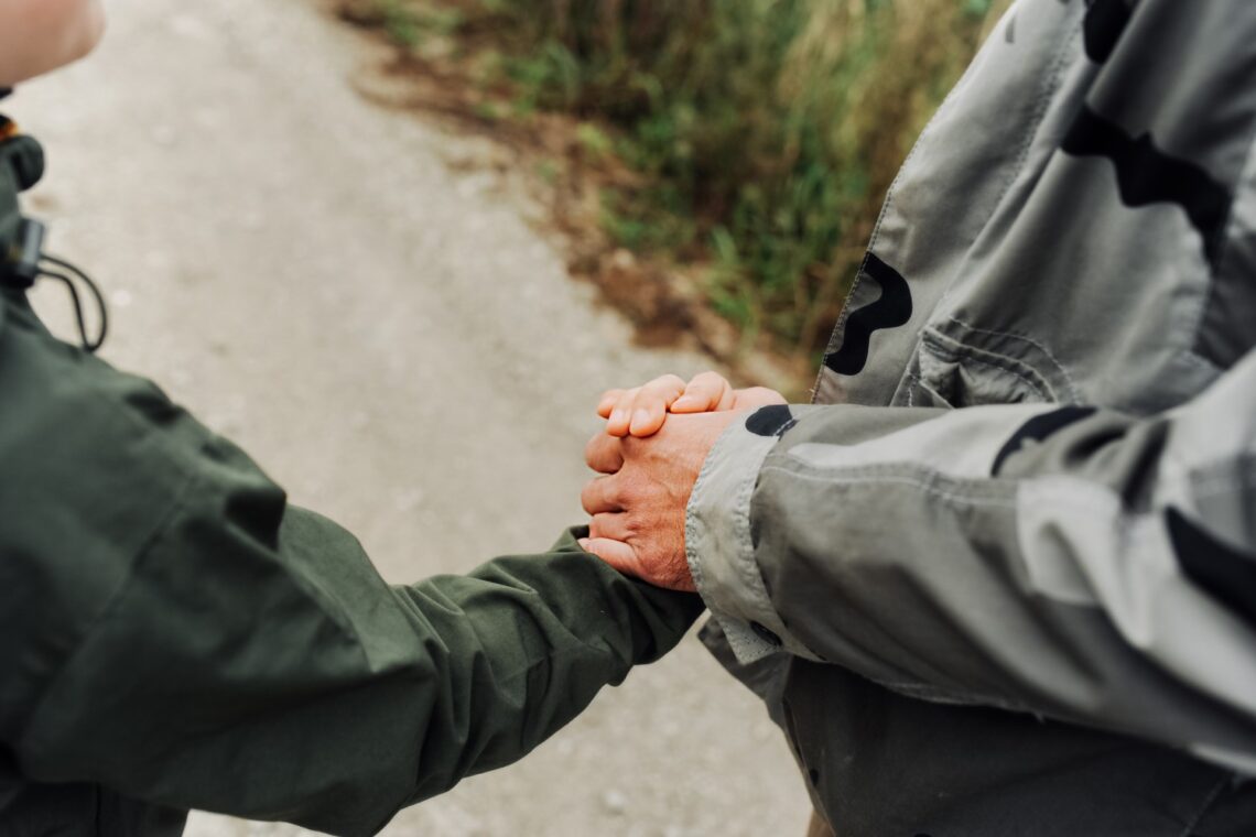 dwoje ludzi, którzy podali sobie ręce w geście pomocy
