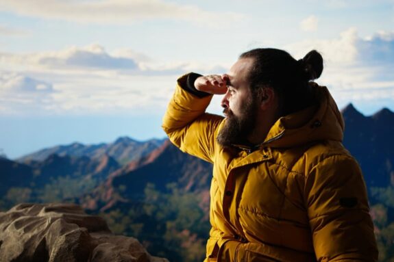 mężczyzna w żółtej kurtce patrzący w dal