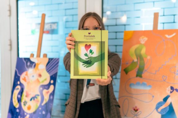 Kobieta trzymająca w rękach przewodnik dla rodziców "Powitalnik"