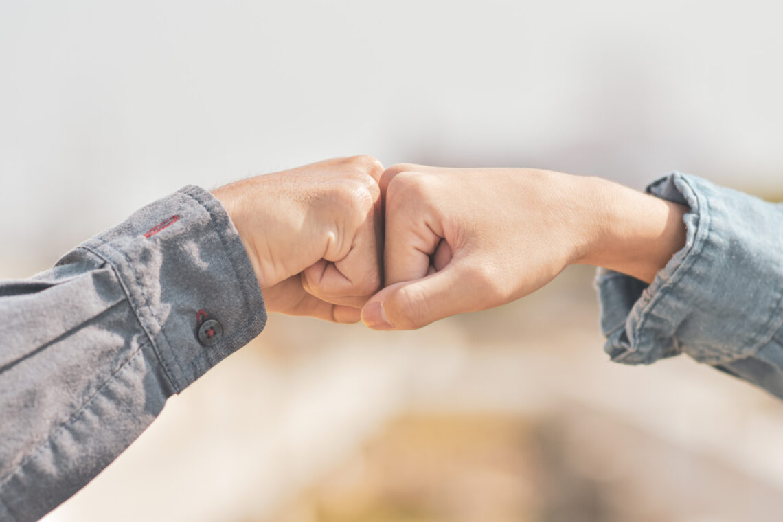 dłoń kobiety i mężczyzny w geście "żółwika"