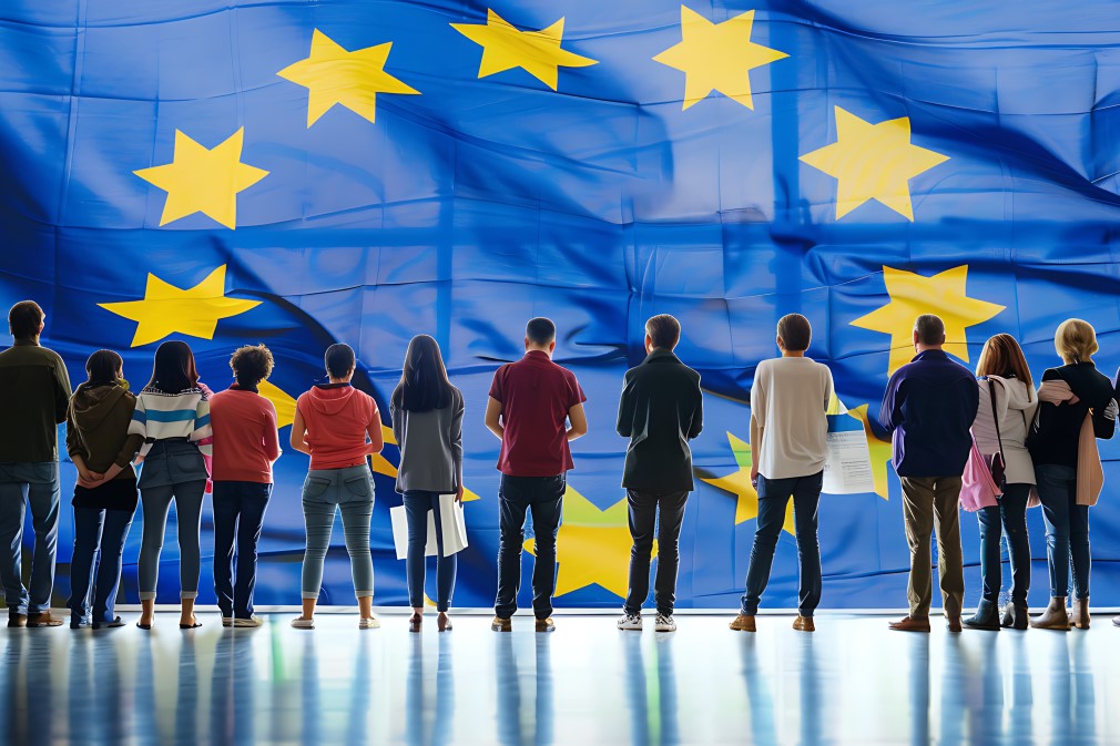 Ludzie stojący przed flagą Unii europejskiej