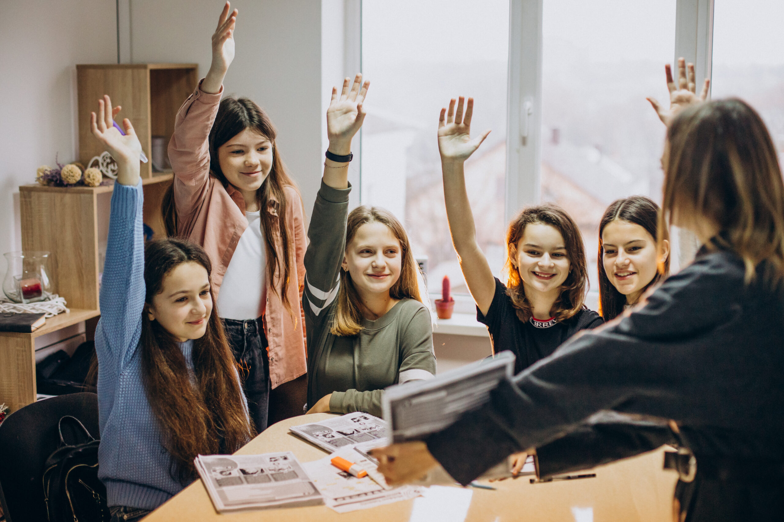 grupa uczennic podnoszących ręce