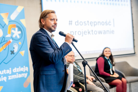 mężczyzna przy mikrofonie podczas konferencji