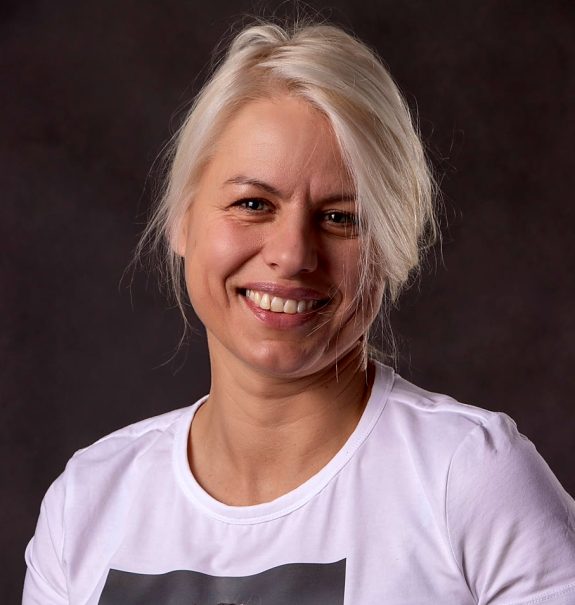 Zdjęcie portretowe uśmiechniętej kobiety z jakimś plakatem na białej bluzce