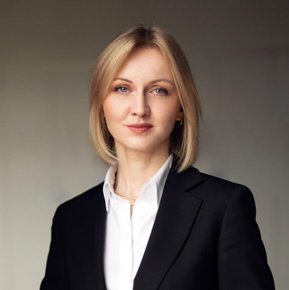 Elegancko ubrana Młoda kobieta z niebieskimi oczami i blond włosami